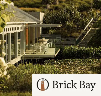 Brick Bay vineyard and restaurant with lakeside architecture in Matakana