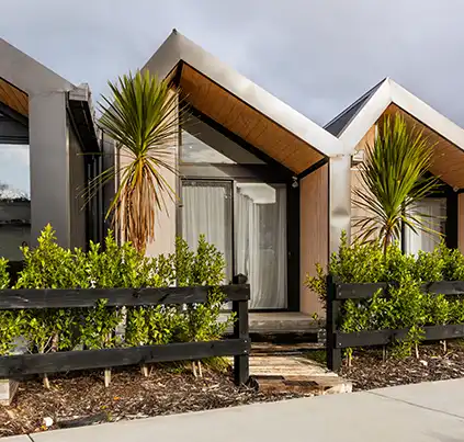 Exterior view of the boutique villas at Matakana Luxury featuring modern timber and steel architecture.